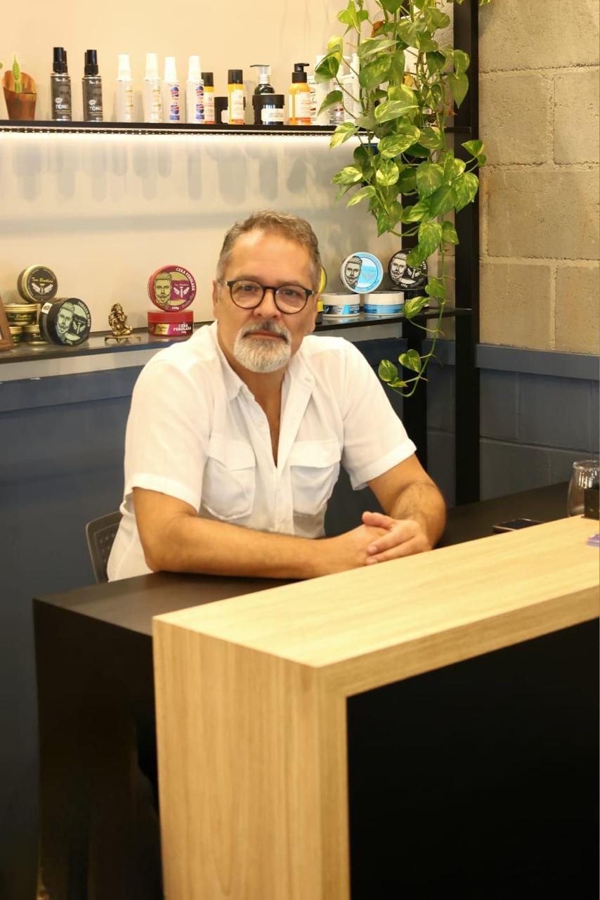 Marcello Ramos sentado no balcão da Lord Ramos Barber Shop